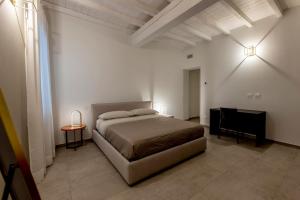 a bedroom with a bed and a chair and a piano at Red Suite - City center & Garage in Parma
