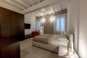 a hotel room with a bed and a red chair at Red Suite - City center & Garage in Parma