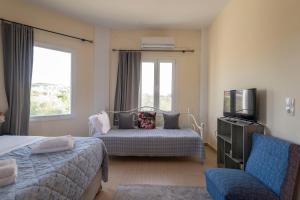 a hotel room with two beds and a television at La Vatura in Gialova