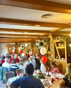 a group of people sitting at tables in a room at Hotel und Restaurant Sackwitzer Mühle in Bad Schmiedeberg