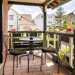 un patio avec une table et des chaises sur un balcon dans l'établissement Villa Cocquelicot 6p, à La Panne