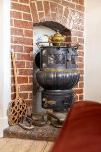 - une cheminée en briques avec une cuisinière dans la chambre dans l'établissement Villa Cocquelicot 6p, à La Panne