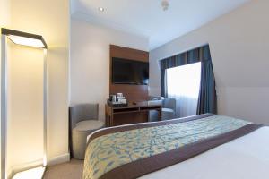 a hotel room with a bed and a desk at Thistle London Piccadilly in London