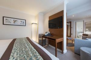 a hotel room with a bed and a desk at Thistle London Piccadilly in London