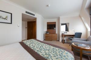 a hotel room with a bed and a desk at Thistle London Piccadilly in London