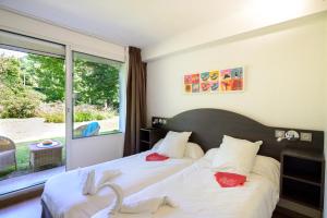 a bedroom with two beds and a large window at Village Club Le Saint Ignace in Ascain +59 photos