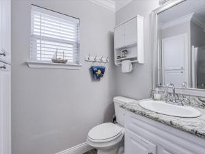 a white bathroom with a toilet and a sink at Simon Michael Art Studio in Rockport +42 photos