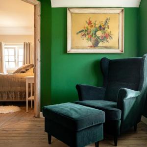a green room with a chair and a painting at Villa Cocquelicot 6p in De Panne