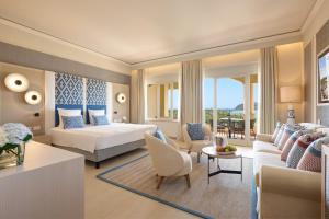 a hotel room with a bed and a living room at Almar Timi Ama Resort & Spa in Villasimius