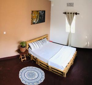 a bedroom with a large bed with white sheets at COZY NYUMBA in Arusha