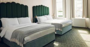 two beds in a hotel room with green headboards at The Columbia in London +33 photos