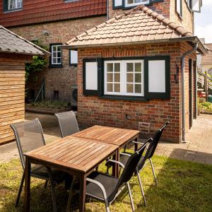 une table et des chaises en bois devant une maison en briques dans l'établissement Villa Cocquelicot 6p, à La Panne 9 autres photos