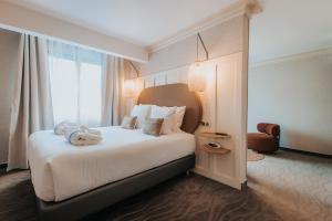 Ένα ή περισσότερα κρεβάτια σε δωμάτιο στο Hôtel Henry II Beaune Centre