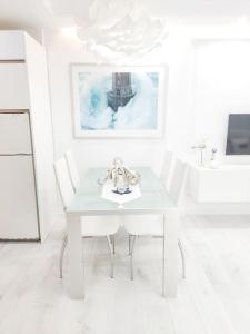 een witte eetkamer met een witte tafel en stoelen bij QBF Quality Beachfront in Torre del Mar