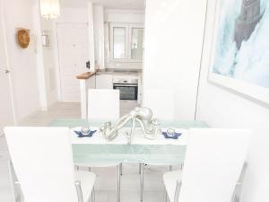 een keuken met een tafel met stoelen en een wastafel bij QBF Quality Beachfront in Torre del Mar