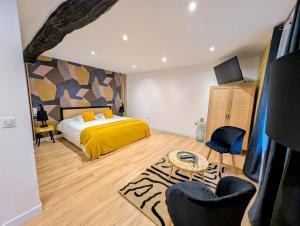 a bedroom with a bed with a yellow bedspread at Le Relais du Beffroi & SPA in Saint-Riquier