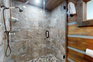 a bathroom with a shower with a stone wall at Goldilocks in Canton +23 photos