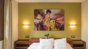 un dormitorio con una pintura de una mujer en una cama en Apartamentos Las Teresitas junto a la Catedral, en Toledo