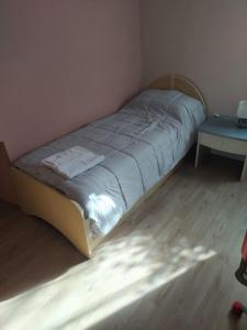 a small bed in a room with a table at Little House in Bracciano