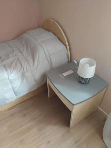 a bed and a table with a lamp on it at Little House in Bracciano
