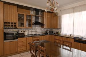 a kitchen with wooden cabinets and a table with chairs at Appartamento in villa "Casa Adele" in Cenate Sotto