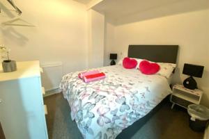 a bedroom with a bed with red pillows on it at Cosy Nook - Town centre flat with free nearby parking, in Shrewsbury