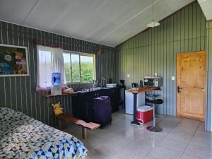a bedroom with a bed and a kitchen with a sink at Tumu Cabin Rapa Nui in Hanga Roa
