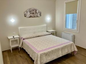 a small bedroom with a bed and two tables at Antico Casale San Pantaleone in Sorbolo