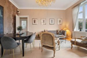a living room with a table and chairs and a couch at 6 pers- Hellerup- Beach & Shopping 100 m- Central in Hellerup