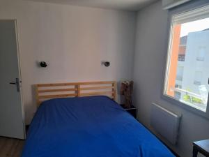 a bedroom with a blue bed and a window at Like home, in Geneva's neighborhood in Ville-la-Grand