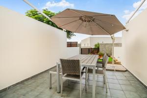 un patio con tavolo, sedie e ombrellone di Agaete Serenity 2BR ad Agaete