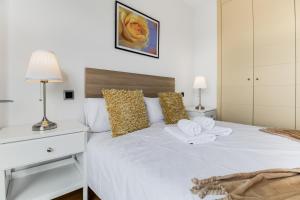 una camera da letto con un letto bianco con asciugamani sopra di Agaete Serenity 2BR ad Agaete