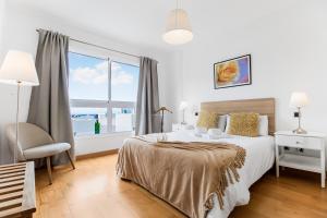 una camera da letto con un letto e una grande finestra di Agaete Serenity 2BR ad Agaete