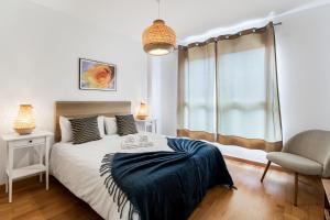 una camera da letto con un letto, una sedia e una finestra di Agaete Serenity 2BR ad Agaete