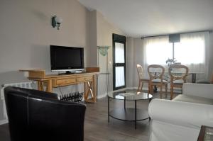a living room with a couch and a tv at Apartamentos Turísticos Espinel Free Parking in Ronda
