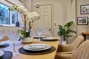 a dining room table with white flowers on it at Fig Tree House in Great Malvern