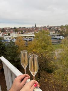 two people holding champagne glasses on a balcony at HomeyHome Strasbourg in Schiltigheim