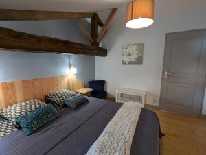 a bedroom with a large bed with blue pillows at La Bonne Chauffe - Serpentin in Verrières +34 photos