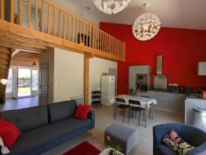 a living room with a blue couch and a kitchen at La Bonne Chauffe - La Longère in Verrières