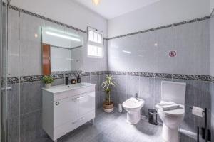 a bathroom with a toilet and a sink and a mirror at Casa Almada in Ribeira Brava +61 photos