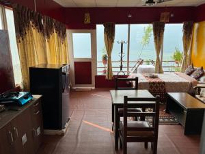 博卡拉Fewa View Cottage Yoga Retreat Pokhara的带床、桌椅的客厅