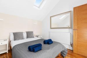 a bedroom with a bed with two blue pillows on it at Two bed Apartment in Leytonstone in London +16 photos