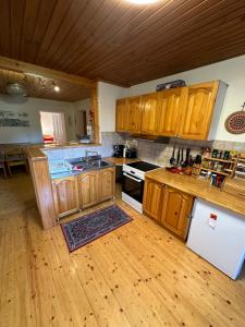 a kitchen with wooden cabinets and a wooden floor at Holiday house Pr Robč in Bovec