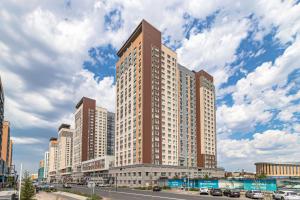 een hoog gebouw in een stadsstraat met auto's bij HIGHVILL PARK in Astana