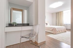 een witte slaapkamer met een bureau en een bed bij HIGHVILL PARK in Astana