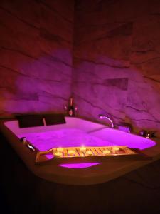 a bath tub with purple lighting in a room at Centrum jacuzzi prywatny parking klimatyzacja 1 in Radom