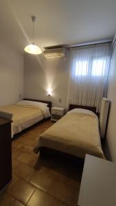 a bedroom with two beds and a window with a light at Eleni's Rooms in Ioannina +17 photos