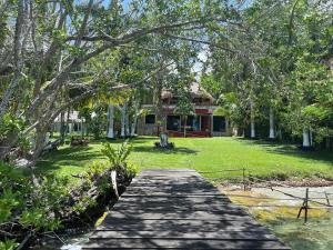 a house with a wooden walkway in front of a yard at Casa Paraíso Maya Bacalar in Bacalar