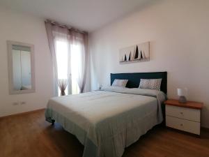 a bedroom with a large bed and a window at Appartamento Delfino Blu in Porto Torres