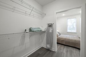 ein weißes Zimmer mit einem Bett und einem Spiegel in der Unterkunft Magnolia Apt - TH03 - Tourist Homes of Richmond in Richmond